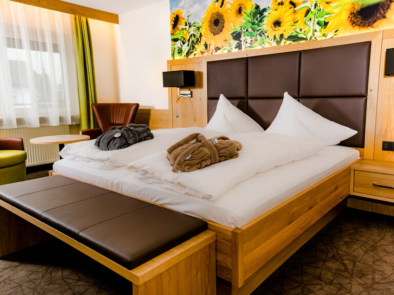 deluxezimmer-mit-sonnenblumendekor helles-holz-laedt-im deluxezimmer-mit-sonnenblumendekor-zum-erholsamen-schlafen-ein