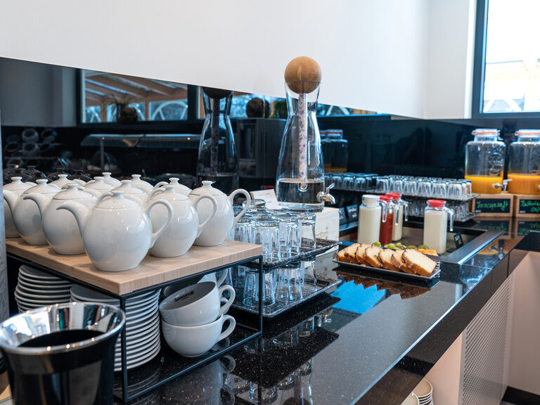 neuer-buffetraum-saftbar-teestation glänzendes-schwarzes-granit-im-neuen-buffetraum-mit-saftbar-einer-teestation-kuehltheke-und-gesundem-zirbenwasser